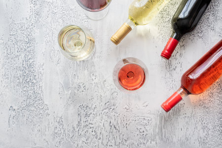 Red, rose and white wine bottles and different wine glasses on concrete background with copy space. top view.の写真素材
