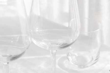 Empty glasses of wine on the white tablecloth. Abstract background.の写真素材