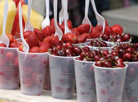 strawberries and cherries in plastic cups from a vendor at the street fairの写真素材