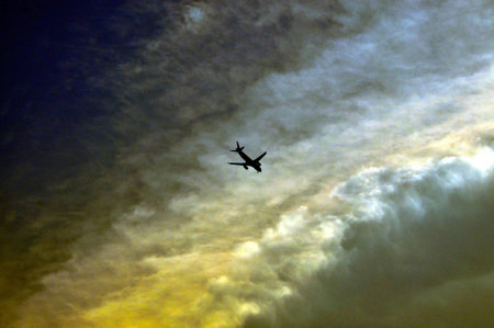 A flight journey through clouds with sun set lightの写真素材