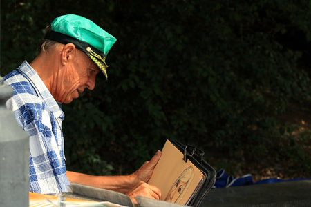 a street artist draws a portrait on a sheet of paper in the Park the city of Vladivostok September 27, 2015のeditorial素材