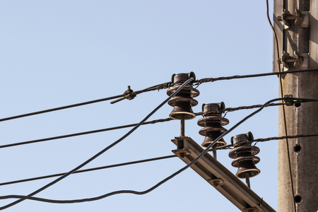 ceramic insulators electric current with wires on a background blue sky