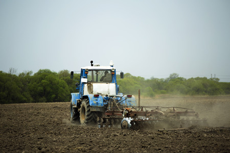 agricultural machinery plowing the landの写真素材