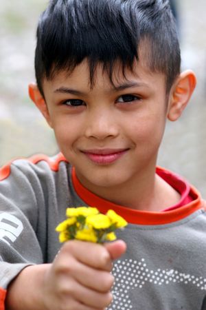 an asian boy presenting the flowersの写真素材