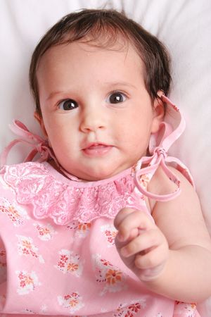 cute baby girl laying in white bedの写真素材