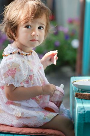 Baby girl eating on the fresh airの写真素材