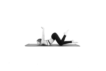 Sporty young woman doing yoga practice isolated on white backgroundの写真素材