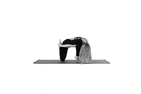 Sporty young woman doing yoga practice isolated on white backgroundの写真素材
