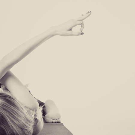 Sporty beautiful young woman practicing yoga, doing high lunge exercise, Reverse Warrior Pose, Viparita Virabhadrasana, working out wearing black sportswear, studio, full lengthの写真素材