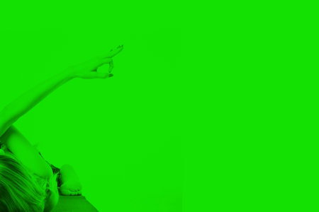 Young girl doing a yoga pose in green colorの写真素材