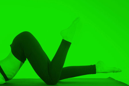 Young girl doing a yoga pose in green colorの写真素材