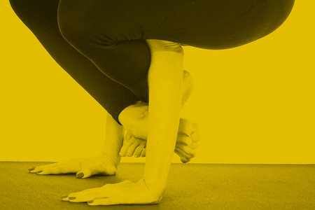 Young girl doing a yoga pose in yellow colorの写真素材