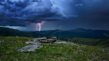 A lightning strike in the mountains of the dark skyの写真素材