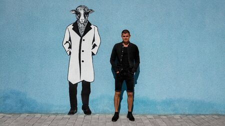 The guy in the black on a blue background with graffiti trendy sheepの写真素材