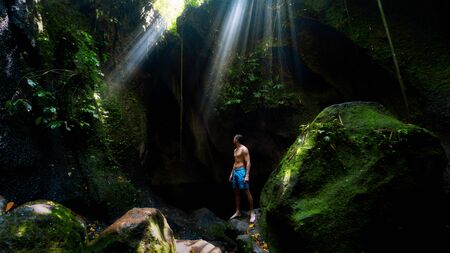 The guy in the canyon the sun's rays beat into the crevice waterfall Tukad Cepungの写真素材