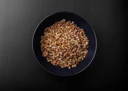 blue plate with buckwheat porridge on the black tableの写真素材