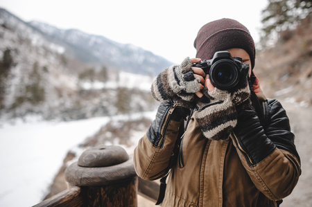Close up portrait of photographer taking pictures with digital camera. Outdoor in winter.の写真素材