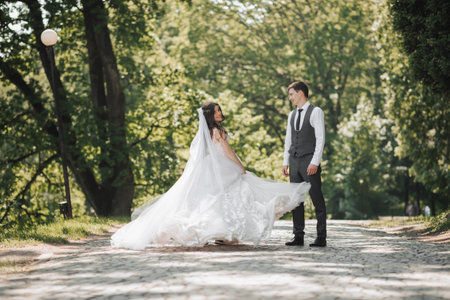 Groom and bride in the garden. Spring wedding in the park. Happy wedding couple running in the park....