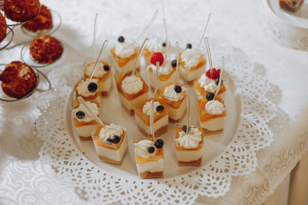 Candy bar. Table with sweets, candies, dessert. cakes and berries in the candy bar. Candy bar with delicious mini cakes, selective focusの写真素材