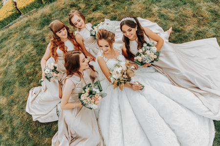 Photo of the bride and bridesmaids with wedding bouquets. Wedding day. Happy girls at their best friend's wedding. Beautiful bride with her friends. Summer weddingの写真素材