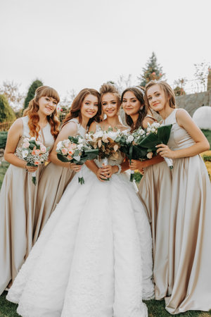 Photo of the bride and bridesmaids with wedding bouquets. Wedding day. Happy girls at their best friend's wedding. Beautiful bride with her friends. Summer weddingの写真素材