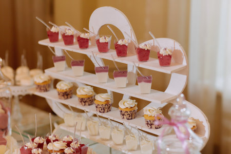 A delicious wedding. Candy bar for a banquet. Celebration concept. Fashionable desserts. Table with...
