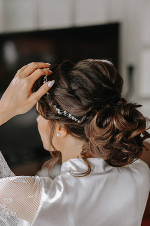 Portrait of a beautiful girl in a wedding dress. Preparation of the bride for the wedding ceremony, morning dressing close-upの写真素材