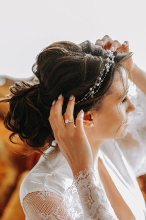 Portrait of a beautiful girl in a wedding dress. Preparation of the bride for the wedding ceremony, morning dressing close-upの写真素材