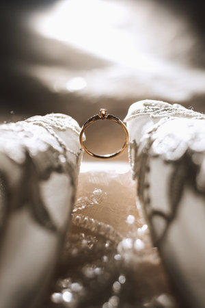 wedding accessories in light colors, shoes, a wedding ring are decoratively arranged in a wonderful backlightの写真素材