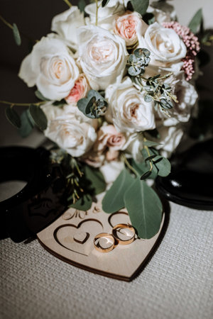 details of the groom are arranged in a composition. Black shoes, wedding bouquet, gold wedding rings on a wooden stand, black men's beltの写真素材