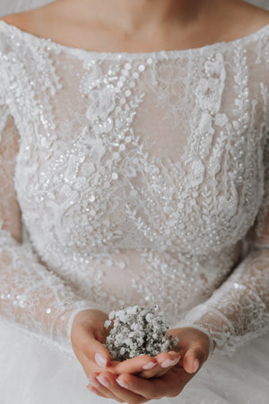 close-up cropped portrait of a bride holding a gypsophila flowerの写真素材