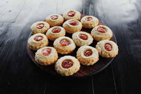 Image of homemade freshly baked cupcakes on a wooden stand and a black background. Lifestyle, baking and spending time at home concept.の写真素材