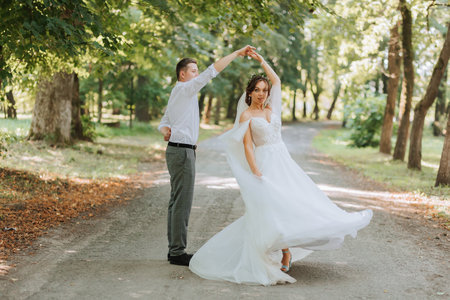 A wedding couple, a happy bride and groom are running in the park to the place of the wedding ceremony. Wedding conceptの写真素材