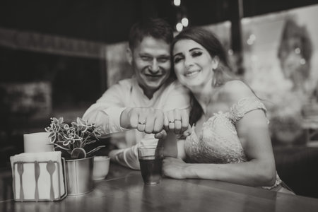 Side view portrait of a loving European couple laughing while enjoying a date in a cafe. Black and white photoの写真素材