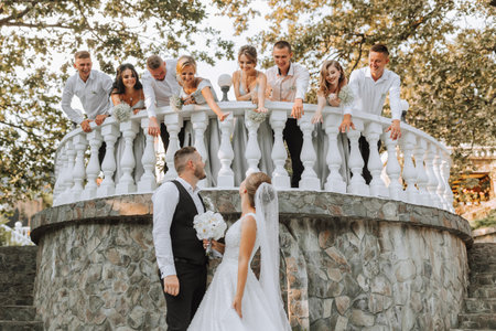 A beautiful couple at a wedding with friends in a beautiful location, staged photoの写真素材