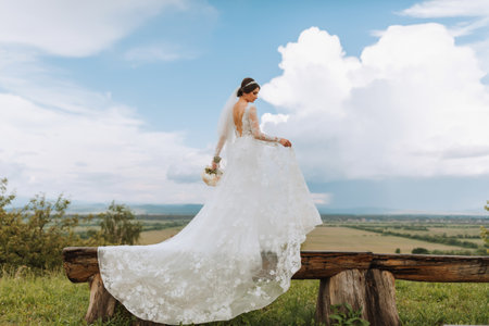 bride stylish against the background of summer mountains. the concept of a rustic wedding in the mountains, happy bohemian newlyweds.の写真素材