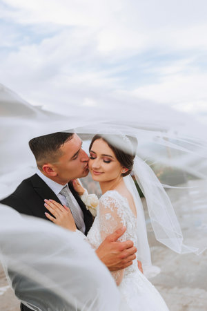 wedding couple on nature. bride and groom hugging under the veil at wedding.の写真素材
