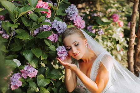 young beautiful bride in off-shoulder wedding dress near hydrangea flowers, fashion photo taken...