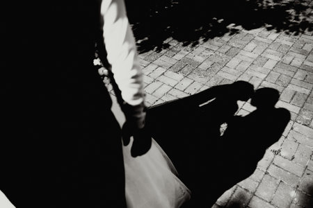 The bride and groom walk after the wedding ceremony. black and white photo, shadow on the tile from the bride and groomの写真素材