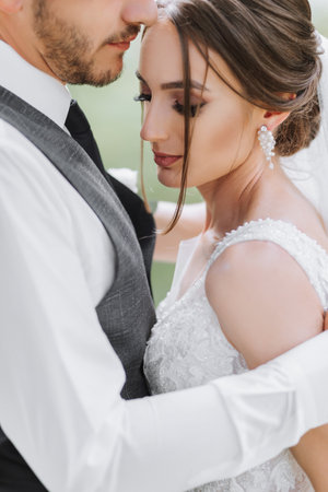 A beautiful wedding, a beautiful couple in love, laughing and kissing against the background of a green garden. High quality photoの写真素材