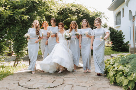 Photo of the bride and bridesmaids with wedding bouquets. Wedding day. Happy girls at their best friend's wedding. Summer weddingの写真素材