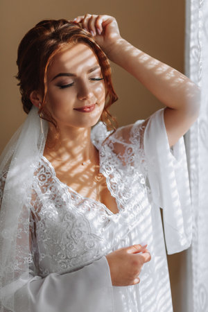 Gold earrings with a crystal on the hand of the bride, close-up. Morning of the brideの写真素材