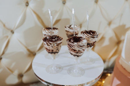 A delicious wedding. White cake decorated with flowers. Candy bar for a banquet. Celebration concept. Fashionable desserts. Table with sweets, candies. Fruitsの写真素材