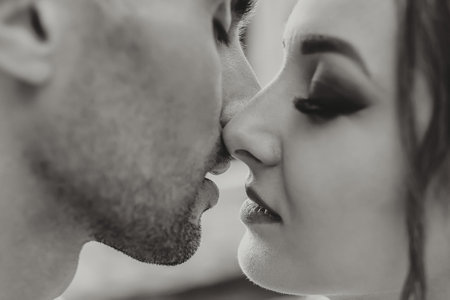 Sensual couple in tender passion. Close-up portrait of a woman about to kiss a man. Couple in love kissing. Sexy lips. Black and white photoの写真素材