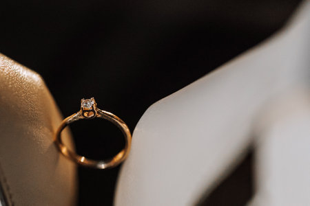 gold women's ring on a dark background, a man makes a marriage proposal to his girlfriend