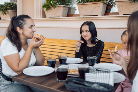a group of teenagers in a cafe eating pizza, chatting and relaxingの写真素材