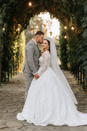 Young wedding couple enjoying romantic moments outdoors on a summer meadow. A bride with a crown on...
