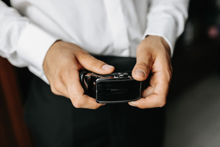 stylish men's leather black belt in man's hands, close-up photo of handsの写真素材