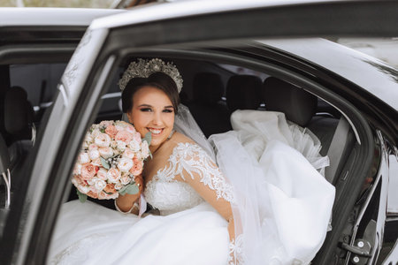 portrait of a happy and smiling bride in the car window looking at the camera