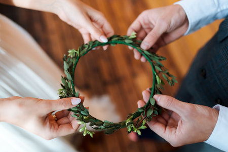 Grooms hold the bride's wreath of greenery. Wedding in a rustic style, details of the bride....